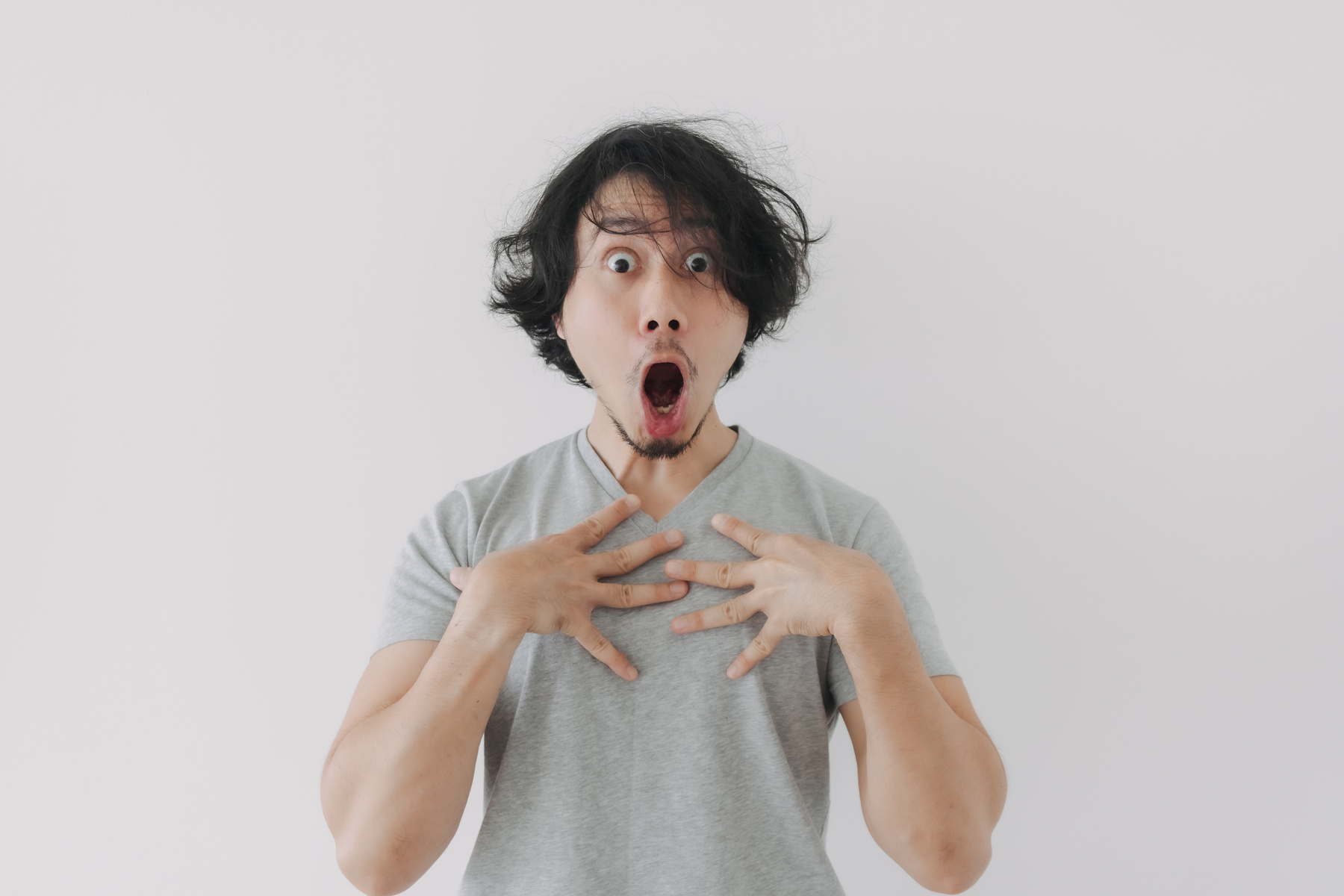 Shocked and Surprised Face of Man in Grey T-Shirt and Long Hair.